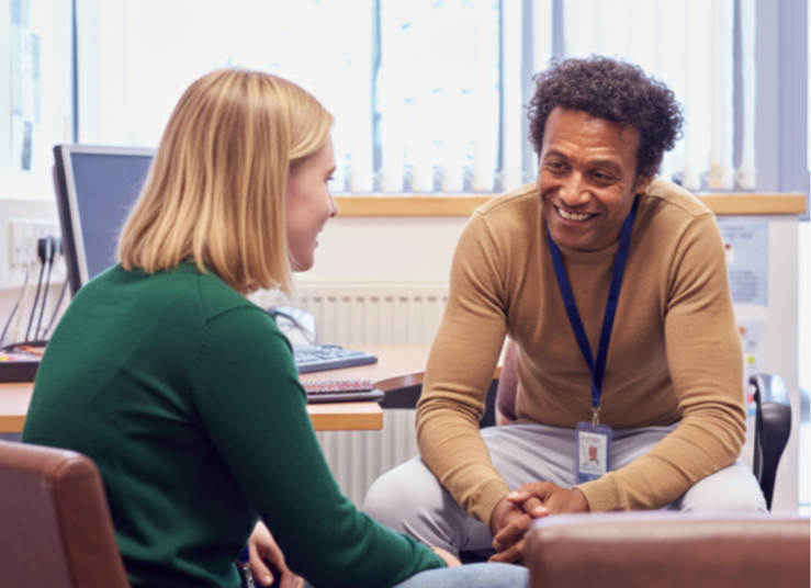 A school counselor works with a student on a laptop